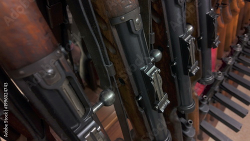 Εκτύπωση καμβά Row of vintage rifles with wooden stocks and metal bolts in military museum, sho
