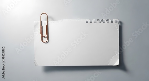 Torn paper note with copper paperclip
