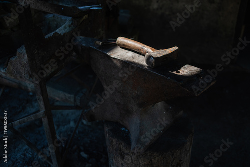 Slika na platnu Blacksmith Hammer Resting on a Metal Anvil in a Traditional Workshop