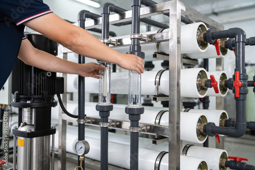 Quadro su tela Technician adjusts flow meter on industrial water purification system with multi