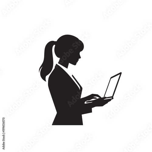 A smiling brunette businesswoman sits in a modern office working on her laptop computer, representing a professional lady utilizing technology and the internet for business and education