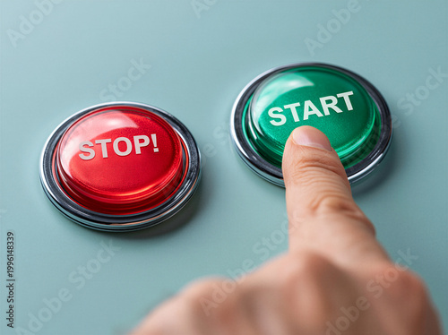 business Mans hand with pointed index finger poised over two buttons, one labled Stop and the other labled Start, about to press on of the red and green buttons - Stop and Start Concept