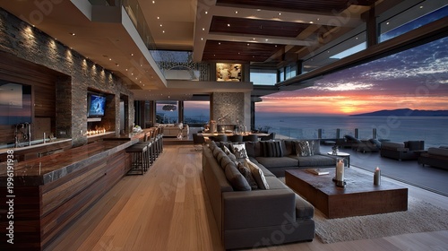 Opulent contemporary interior living space opens to a dramatic ocean sunset panorama