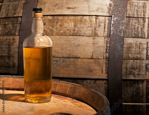 Canvas Print Old bottle of Irish Whiskey sitting on a wooden barrel