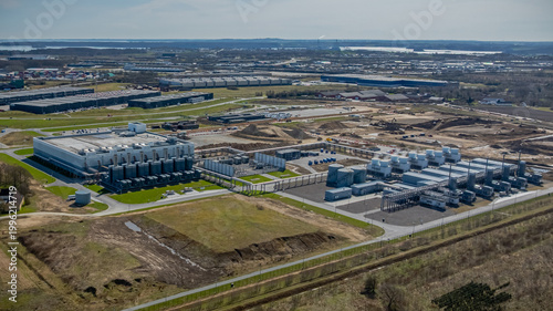 Large-scale data center campus with computing facilities  energy supply systems and advanced cooling infrastructure  undergoing expansion with visible construction areas, earthworks.