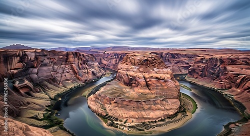 Horseshoe bend in page, arizona, featuring the colorado river winding through a dramatic desert canyon under a cloudy sky
