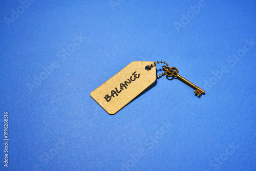 Key to Balance Concept A Golden Key and Tag on Blue Background