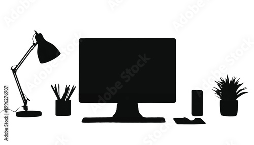 Computer monitor sits on a desk with a lamp and office supplies to represent a modern workspace area.