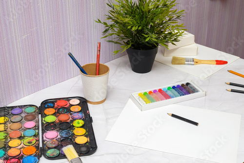 close up of paints brushes and drawing supplies