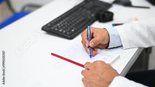1080p 60fps horizontal video of a doctor writing a prescription to his patient in his office, both of Latino origin
