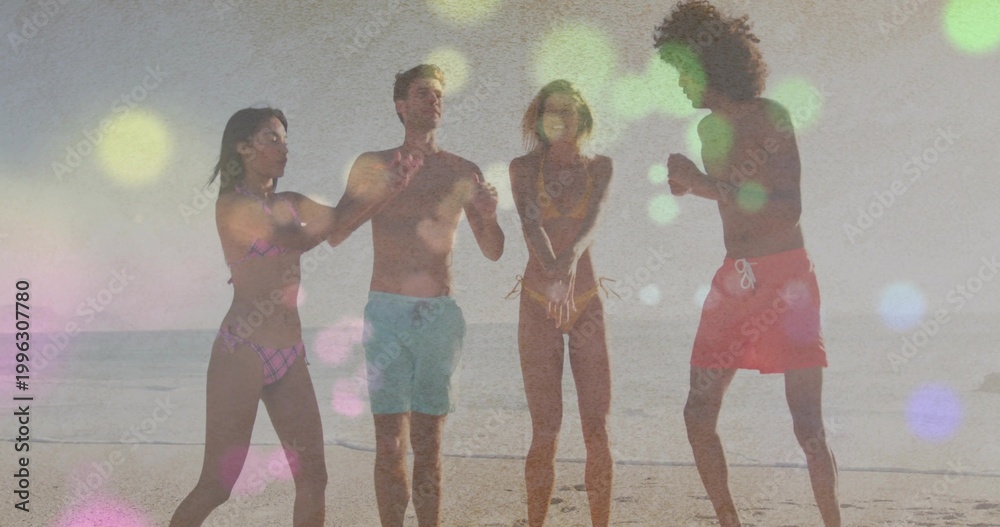 Fototapeta premium Playing group of four friends raising arms and splashing at sandy beach shoreline, swimsuits, bokeh
