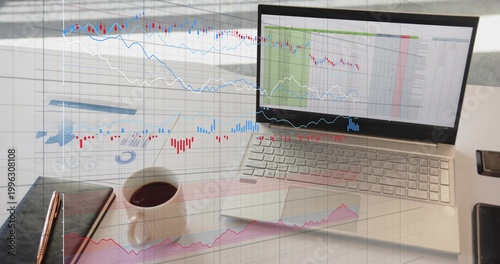 Displaying laptop showing spreadsheets and market overlays in office with notebook, mug, report