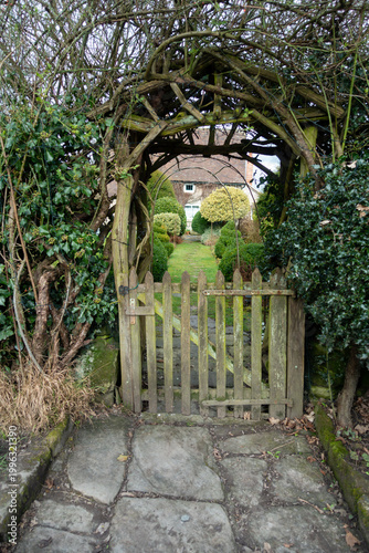 Old fashioned wooden gateway, and entrance to a garden path leading to a country cottage in rural England.