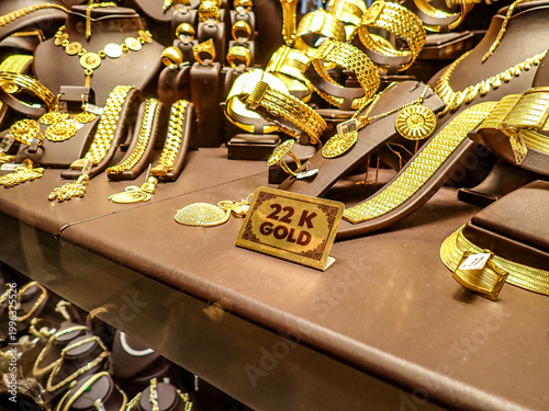 Canvas Print Close up of 22 karat gold jewelry including bracelets, necklaces and rings arranged on a shop counter with a sign indicating gold purity