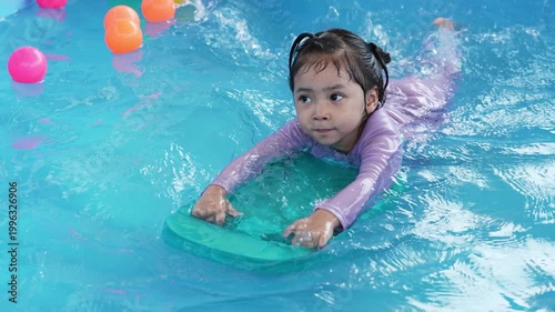 slow motion of preschool child girl playing in portable swimming pool in backyard at home