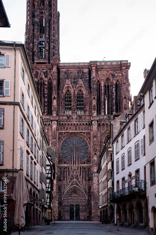 Fototapeta premium Towering Spire Rising Above Narrow Street Dramatic View