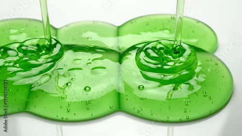 Viscous green liquid pouring onto white surface in macro view
