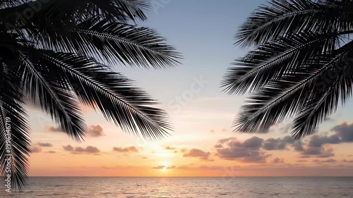 Beautiful tropical sunset over the sea framed by palm tree branches, summer vacation background.