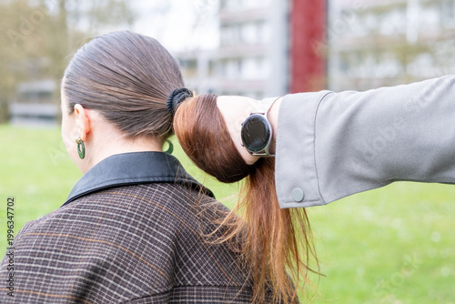 Foto hand grabbing woman's ponytail, victim domestic violence, aggression, relationsh