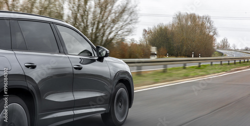 Profile of a modern SUV on the track. The car is moving fast.