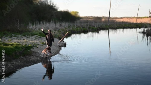 Young Children Play by a Calm River at Golden Hour, Enjoying Nature and Splashing Water in a Serene Outdoor Environment