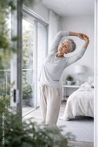 Mature woman stretching in modern bedroom with natural light