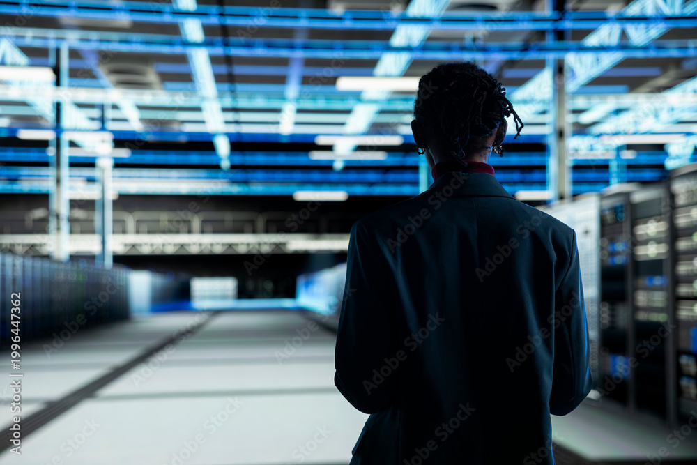 Fototapeta premium Admin walking in data center, configuring server settings with software. IT professional in modern high tech server hub doing maintenance tasks on infrastructure electronics