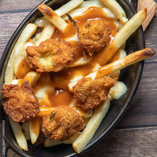 Above close up view of a dish of dill pickle poutine hot out of the oven.