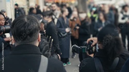 Photographers and paparazzi taking pictures at fashion event