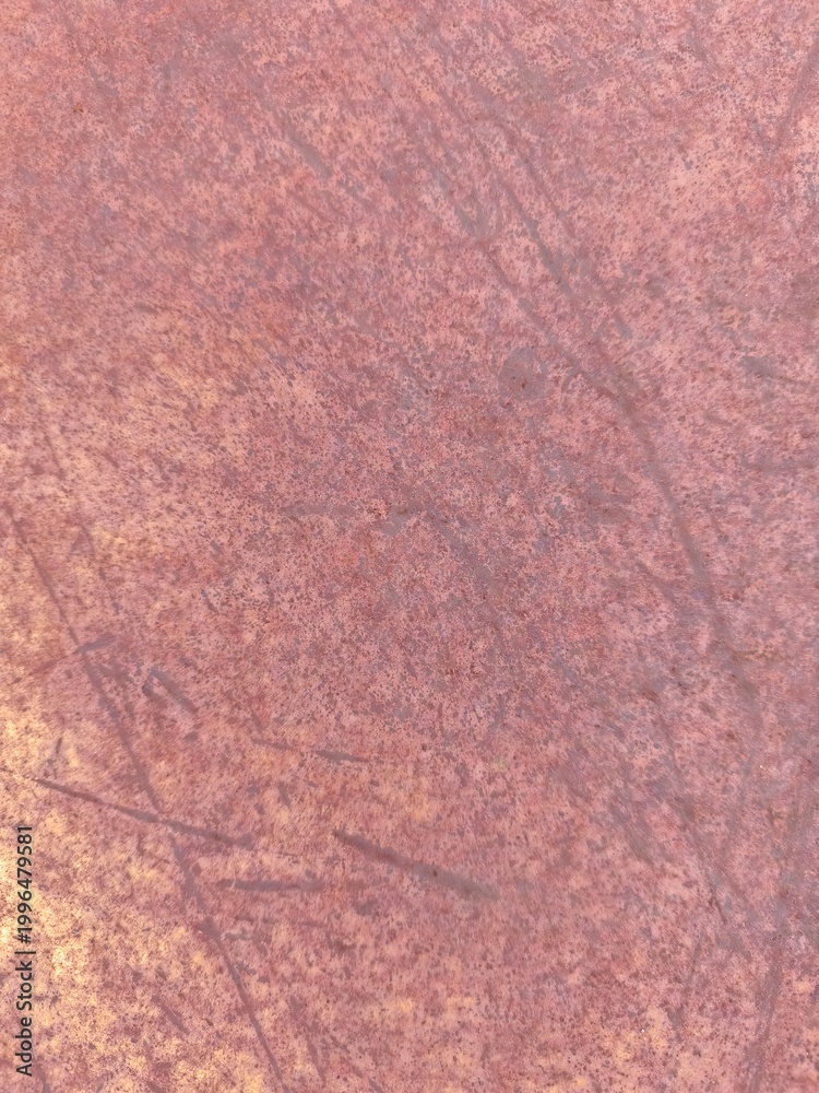 Fototapeta premium Closeup of a weathered rust metal surface showing varied oxidation patterns, brown and orange discoloration, dust accumulation, and uneven corrosion across the deteriorating material.