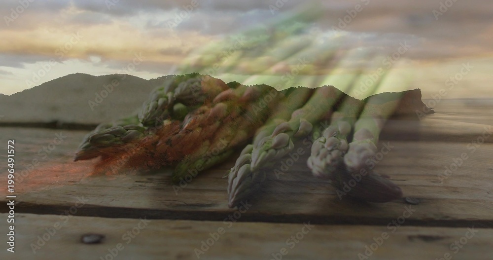 Obraz premium Displaying fresh green asparagus spears lying diagonally on wood plank near shore with metal screw