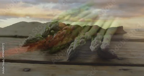 Fototapeta Displaying fresh green asparagus spears lying diagonally on wood plank near shore with metal screw