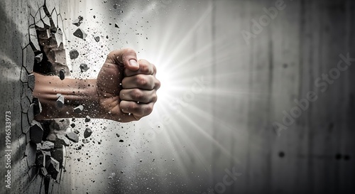 Powerful fist breaking through a concrete wall with bright light