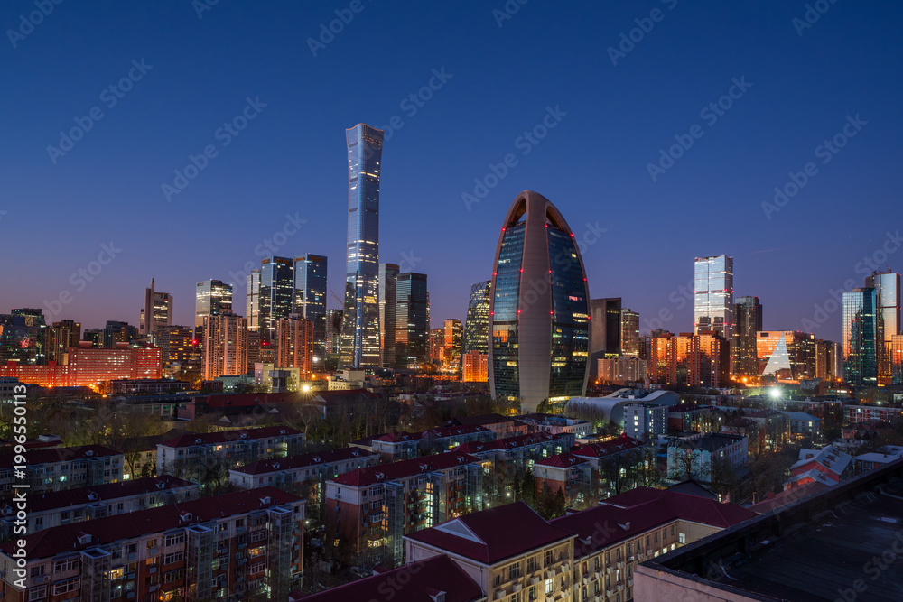 Fototapeta premium Morning blue hour over the Beijing CBD skyline featuring CITIC Tower (China Zun) and People's Daily Building, showcasing modern urban development