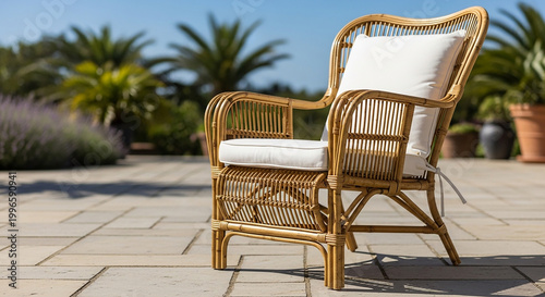 Wicker armchair with white cushions on a patio with palm trees wicker chair outdoor furniture