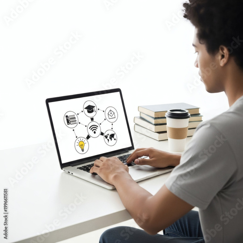 A young man working on a laptop with books and coffee nearby