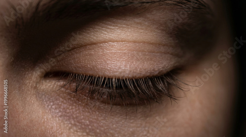Extreme close up of human eye closed in dark peaceful sleep