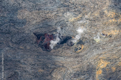 Active lava field with red glowing lava and fumes rising, on the Big Island of Hawaii. 
