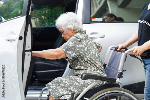Caregiver help Asian elderly woman disability patient get in her car.