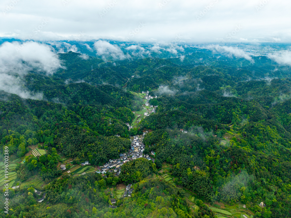 Fototapeta premium An aerial view shows the traditional village of Huizhou Ancient City located in the rural mountains of She County in Anhui province of China during a misty and cloudy morning