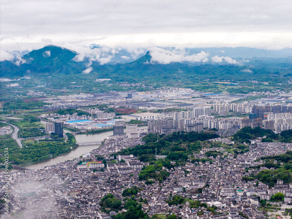 Fototapeta premium An aerial view captures the traditional architecture and scenic landscape of the Huizhou Ancient City in She County located within the Anhui province of China on a cloudy day