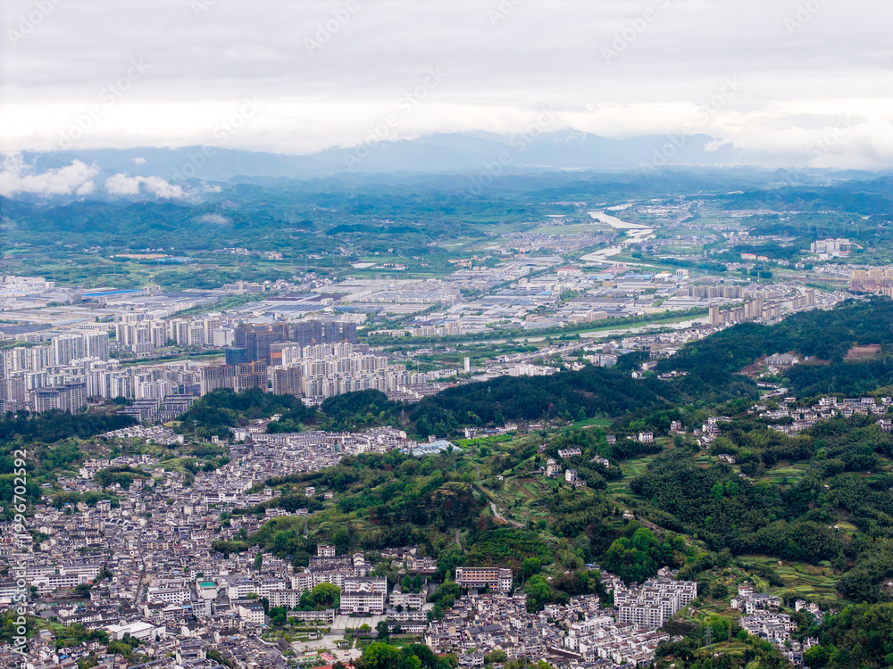 Obraz premium Aerial view of Huizhou Ancient City, She County, Anhui, China, showcasing its urban landscape with mountains and a winding river
