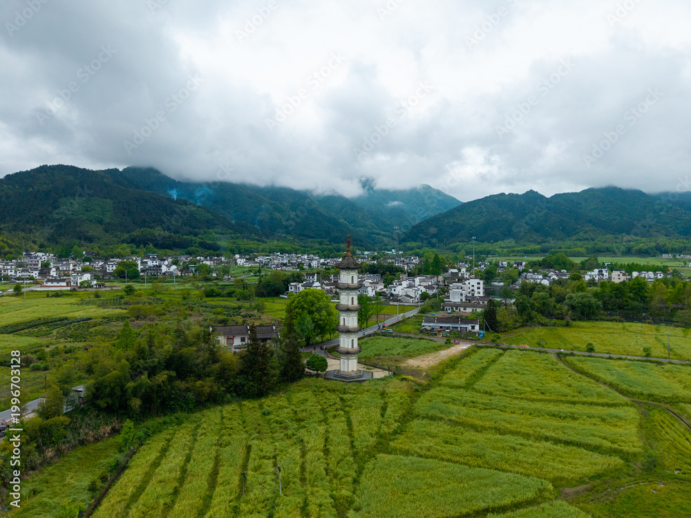 Obraz premium An aerial view captures the traditional architecture of the ancient Hongcun Village located in Yixian County of Anhui Province in China with lush green fields and mountains in the background