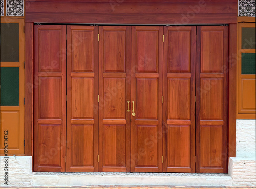 Traditional Thai style folding wooden doors with bronze handles