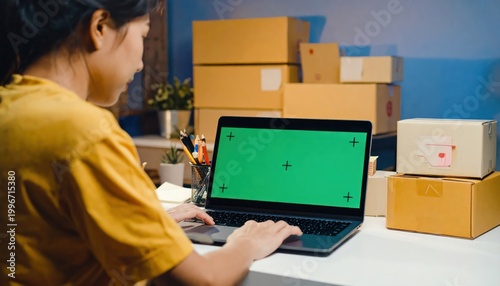 Woman managing online business with laptop surrounded by packages.