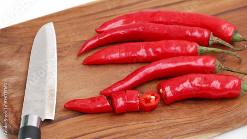 red hot chili pepper on wooden cutting board isolated on white	