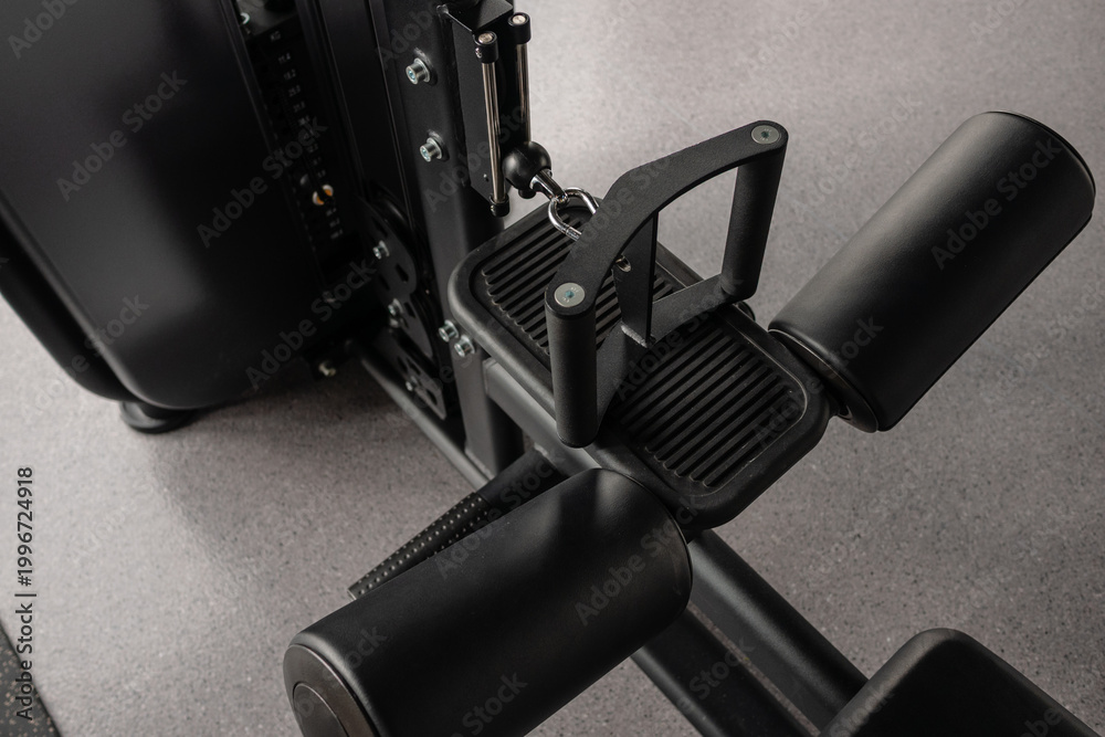 Obraz premium Close-up of leg extension machine seat and pads in modern gym equipment detail