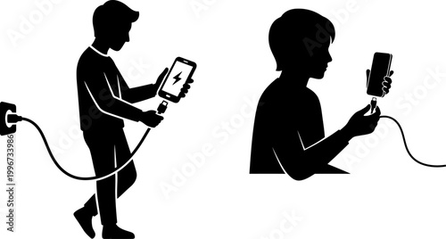 Silhouette of a boy charging his smartphone with a cable connected to a wall power outlet