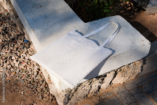 Canvas tote bag mockup on stone bench outdoor