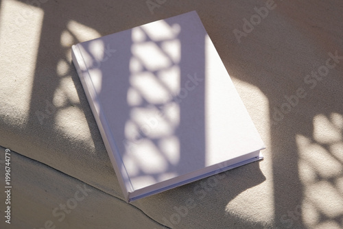 blank book mockup on lounge chair , tile floor outdoors